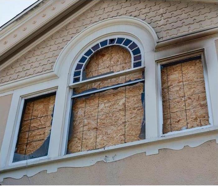 house with a window boarded up