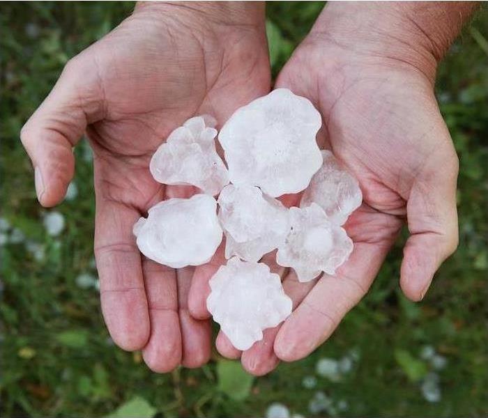 2 hands holding rocks of hail